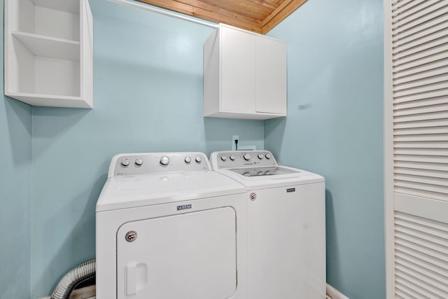 clothes washing area featuring cabinet space and washing machine and clothes dryer