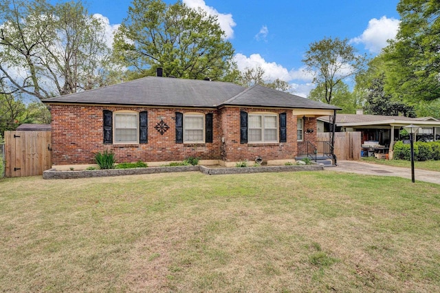 ranch-style home featuring brick siding, a front lawn, and fence