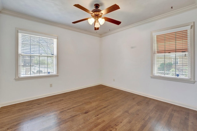 spare room with plenty of natural light, baseboards, crown molding, and wood finished floors