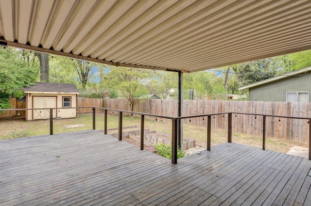 wooden terrace with a storage shed, an outbuilding, a fenced backyard, and a lawn