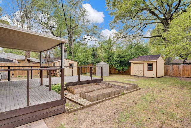 view of yard with a storage unit, a fenced backyard, an outbuilding, a deck, and a vegetable garden