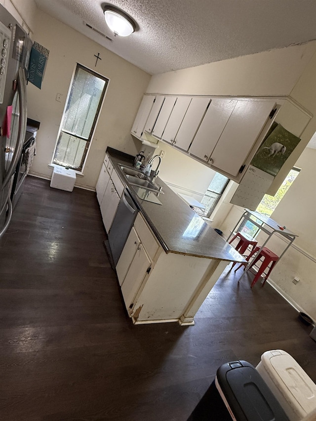 3287 Leschallas Dr, Memphis, TN 38128 - kitchen featuring a sink, dark wood-style flooring, dishwasher, and a textured ceiling