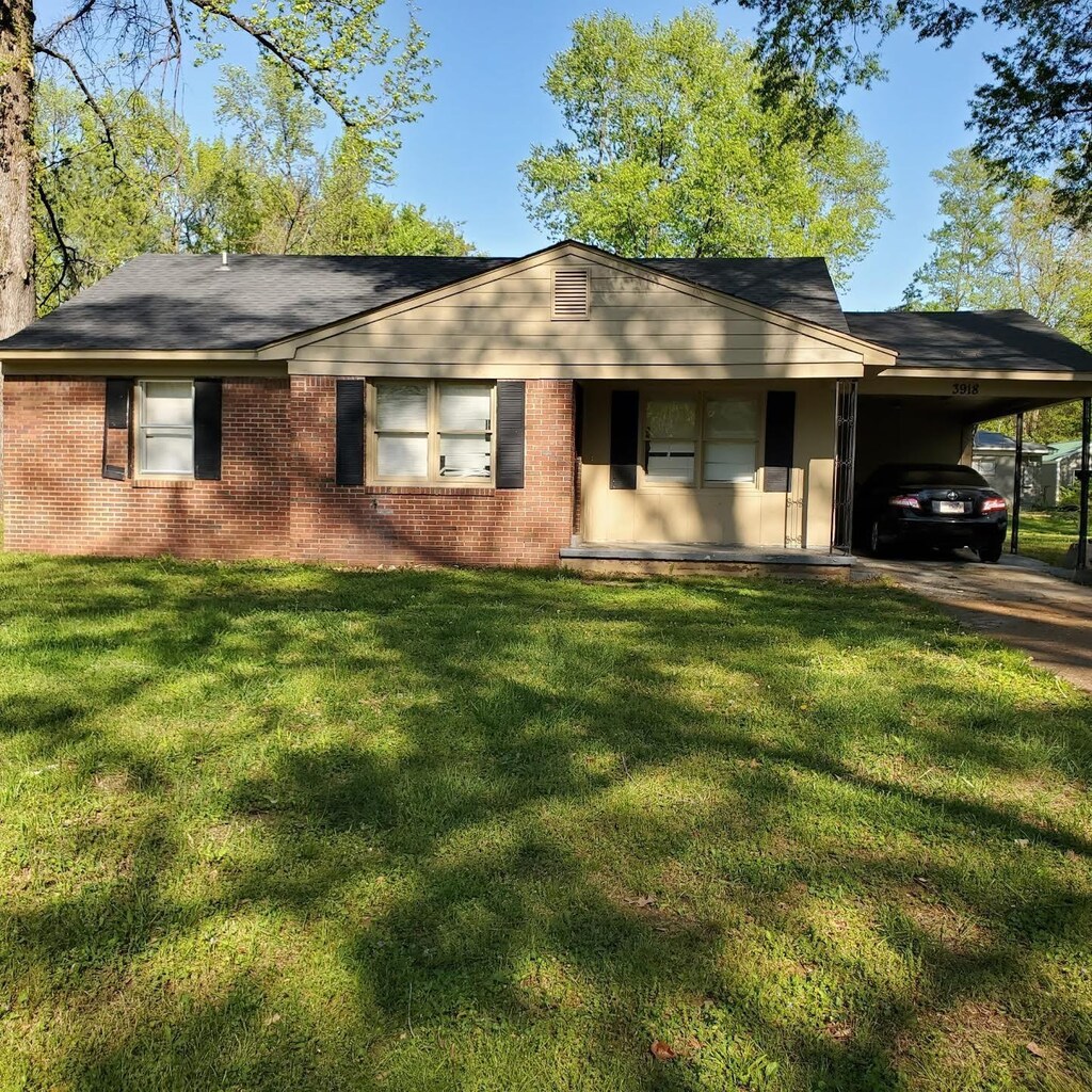 3918 Argonne St, Memphis, TN 38127 - ranch-style home featuring a front yard, driveway, brick siding, and a carport
