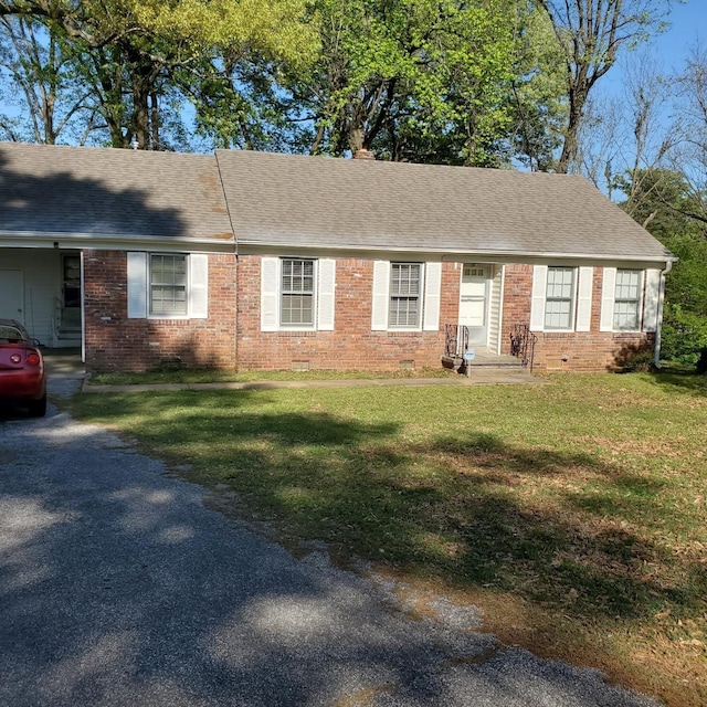 single story home featuring a front yard, entry steps, a shingled roof, and brick siding