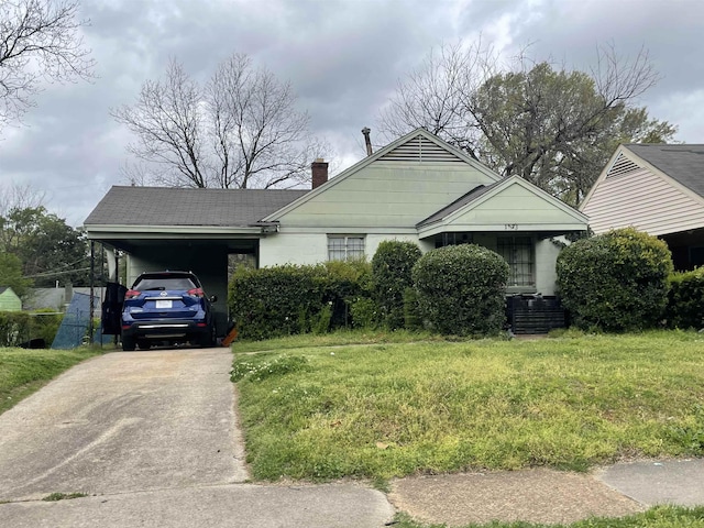 view of front of house with a carport, a chimney, driveway, and a front yard
