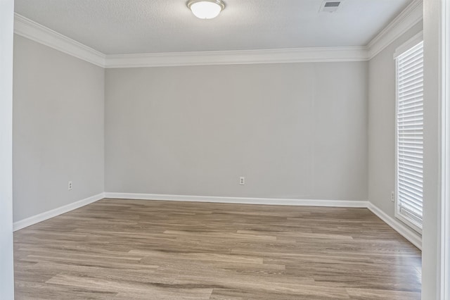 empty room featuring light wood-style floors, baseboards, ornamental molding, and a wealth of natural light