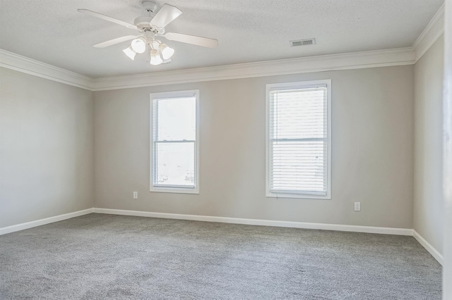 carpeted spare room with visible vents, baseboards, ornamental molding, ceiling fan, and a textured ceiling