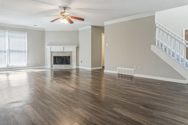 unfurnished living room with dark wood-style flooring, a ceiling fan, visible vents, and stairway