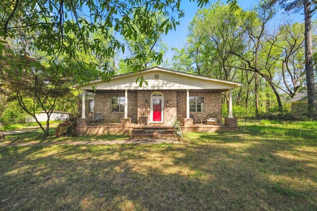 view of front of house with a porch, brick siding, and a front lawn
