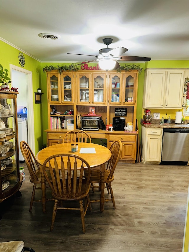 dining area featuring visible vents, ornamental molding, ceiling fan, light wood-style floors, and washer / dryer
