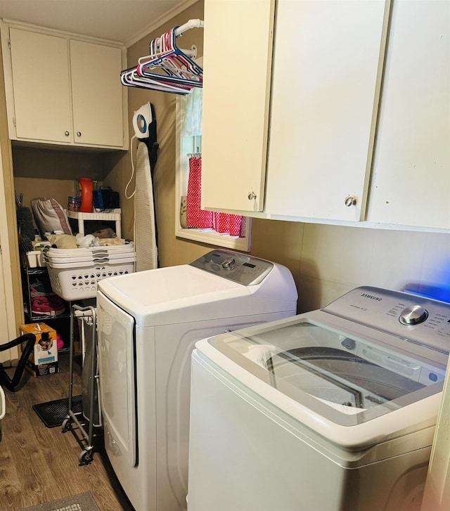 laundry room featuring independent washer and dryer, wood finished floors, and cabinet space