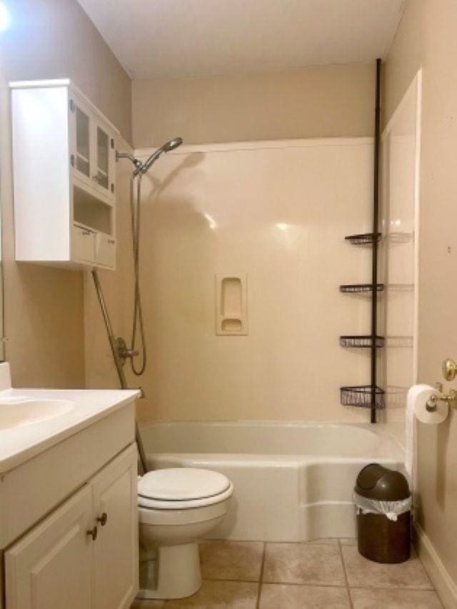 full bath with shower / tub combination, tile patterned floors, vanity, toilet, and baseboards