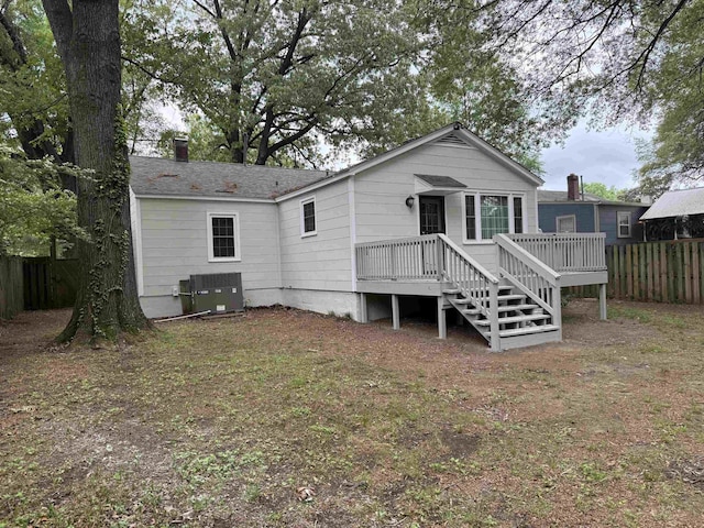 back of property with central AC, fence, a wooden deck, and a chimney