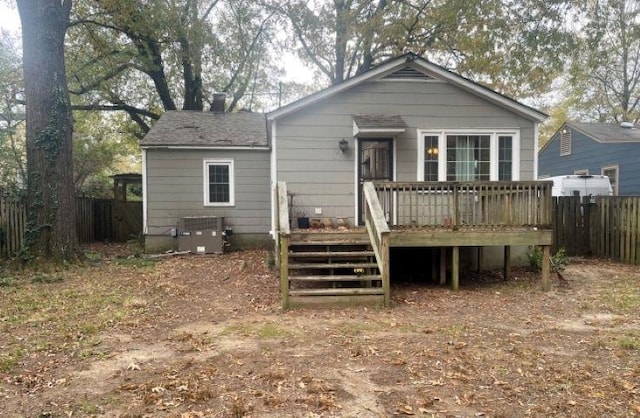 back of property featuring fence, a wooden deck, and central air condition unit