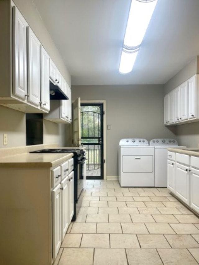 laundry room featuring washer and clothes dryer, baseboards, and cabinet space