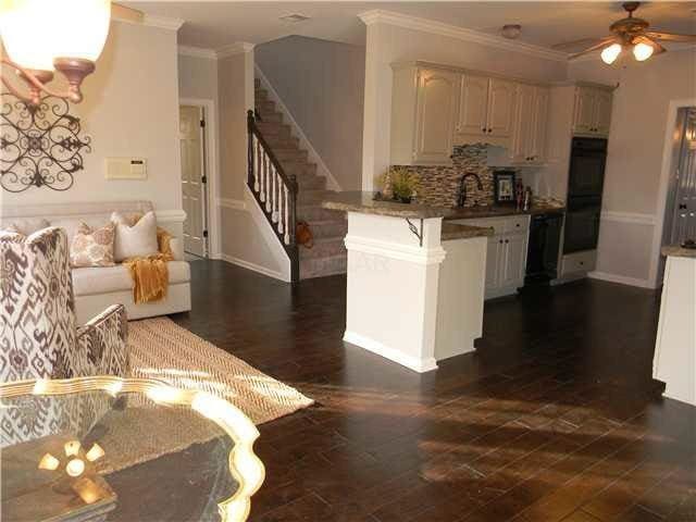 kitchen with a peninsula, a ceiling fan, a kitchen breakfast bar, and crown molding