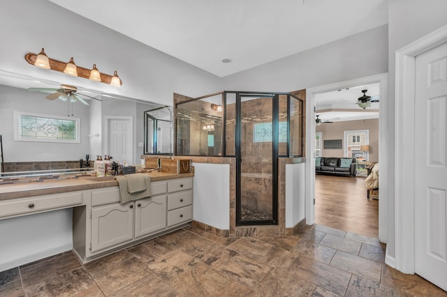 full bathroom with a shower stall, a ceiling fan, and stone tile flooring