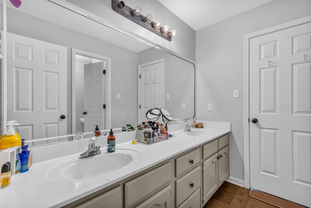 bathroom featuring wood finished floors, double vanity, and a sink