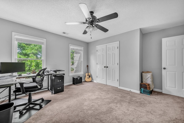 office featuring a ceiling fan, visible vents, carpet floors, and a textured ceiling