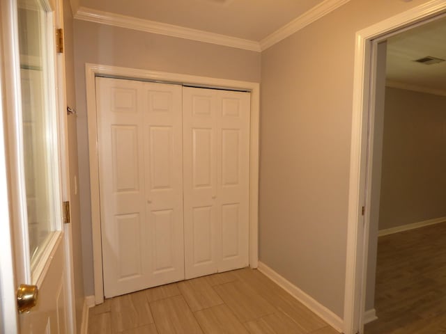 hallway with ornamental molding, baseboards, and visible vents