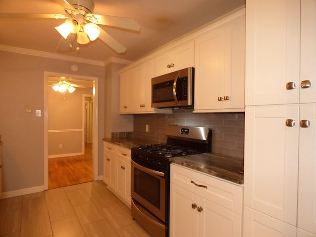 kitchen featuring stainless steel appliances, tasteful backsplash, white cabinetry, and a ceiling fan