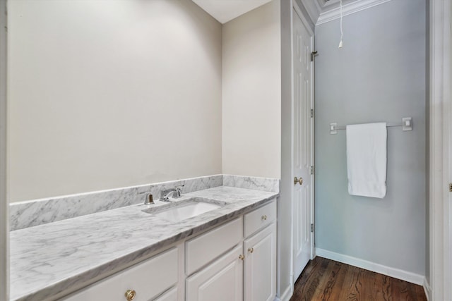 bathroom with wood finished floors, vanity, and baseboards
