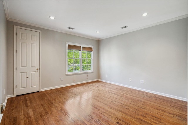 empty room featuring crown molding, visible vents, and baseboards
