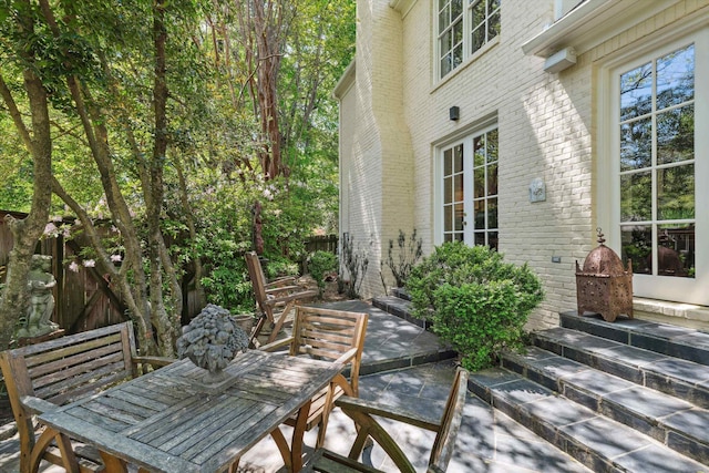 view of patio / terrace with outdoor dining space, entry steps, and fence