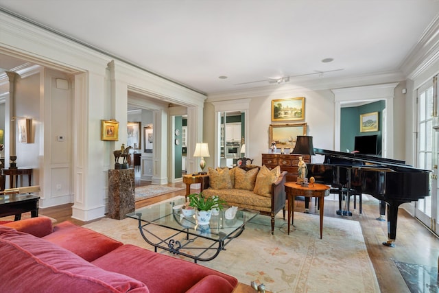 living room featuring ornamental molding, ornate columns, and wood finished floors