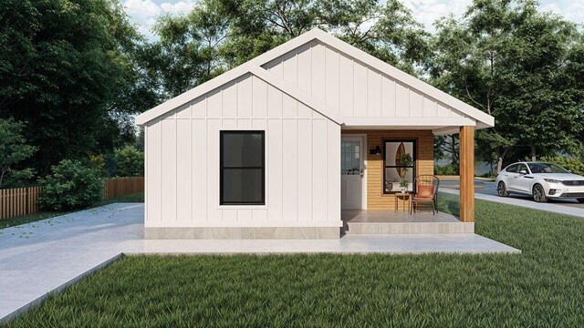exterior space featuring board and batten siding, a front yard, fence, and covered porch