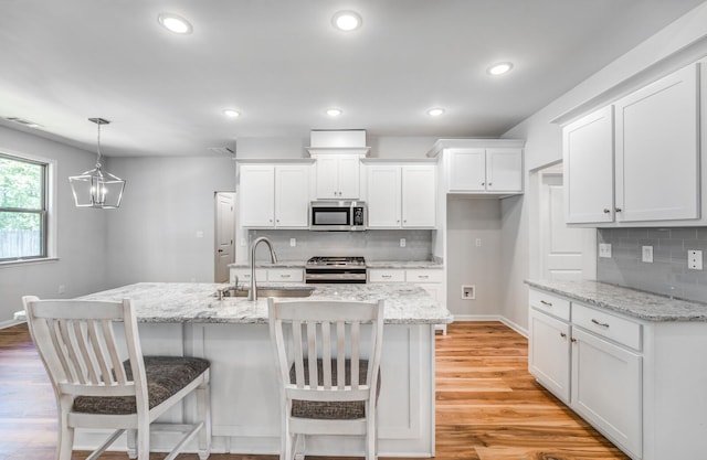 175 Valleyview Ln, Oakland, TN 38060 - kitchen featuring tasteful backsplash, decorative light fixtures, a sink, white cabinetry, and stainless steel appliances