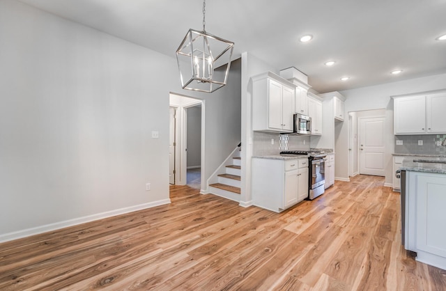 175 Valleyview Ln, Oakland, TN 38060 - kitchen with light wood-style floors, an inviting chandelier, appliances with stainless steel finishes, decorative backsplash, and baseboards