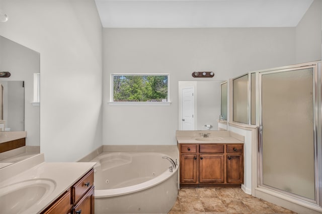 bathroom with two vanities, a sink, a stall shower, and a tub with jets
