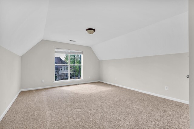 additional living space featuring vaulted ceiling, carpet floors, and baseboards