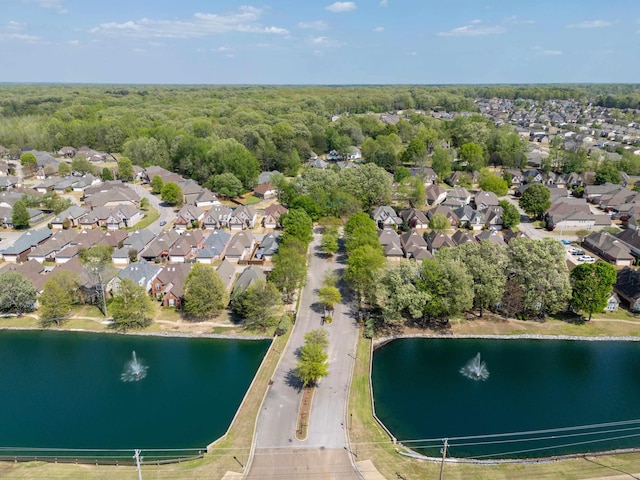 drone / aerial view featuring a view of trees, a residential view, and a water view