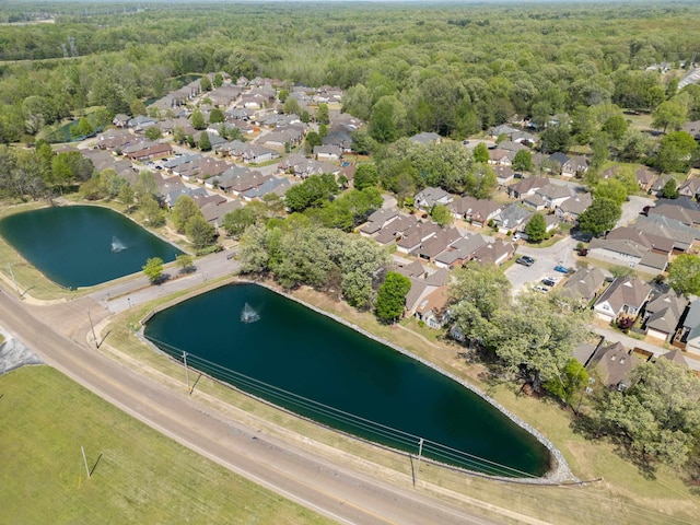 drone / aerial view with a forest view, a water view, and a residential view