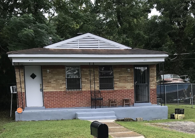 bungalow-style home with a porch, fence, and brick siding