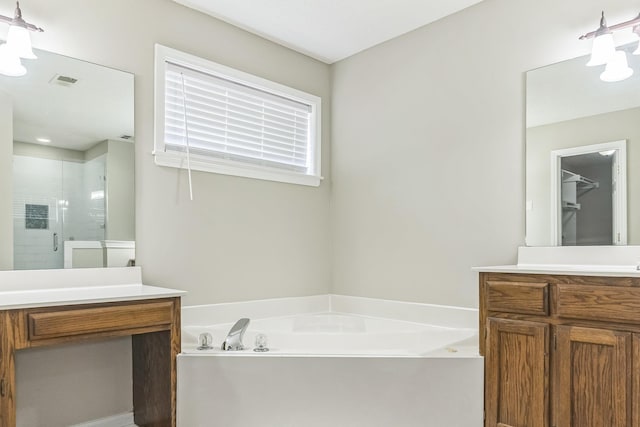 full bathroom featuring a shower stall, vanity, visible vents, and a garden tub
