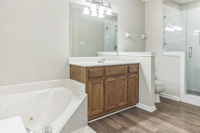 bathroom with a shower stall, vanity, toilet, wood finished floors, and a whirlpool tub
