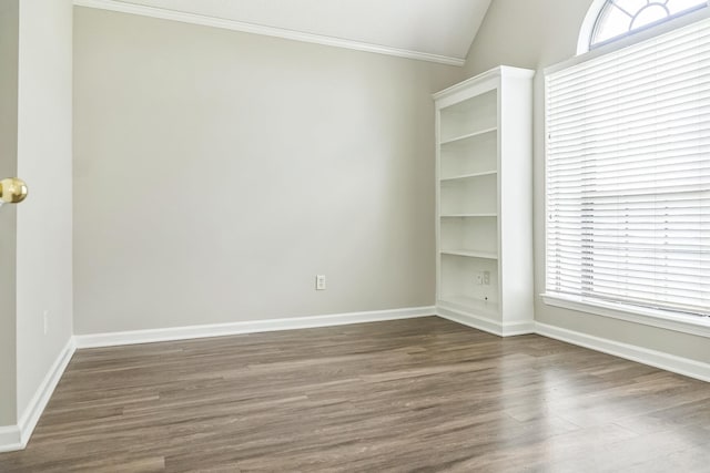 unfurnished room featuring crown molding, wood finished floors, baseboards, and vaulted ceiling
