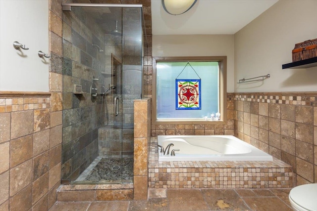 full bath featuring a stall shower, a garden tub, and tile walls
