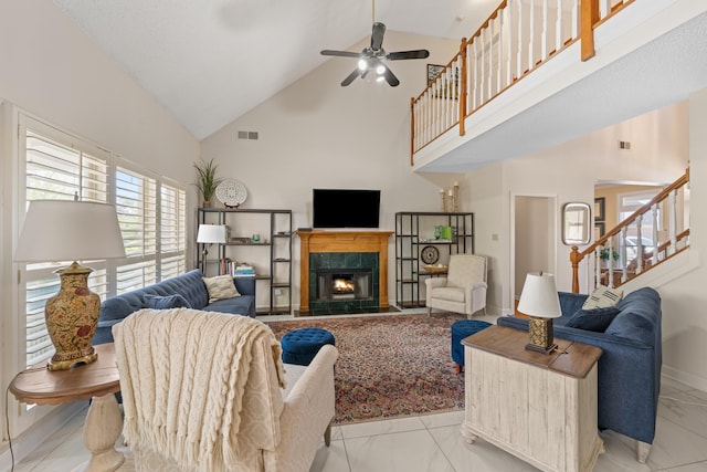living room featuring visible vents, a fireplace, stairs, high vaulted ceiling, and marble finish floor