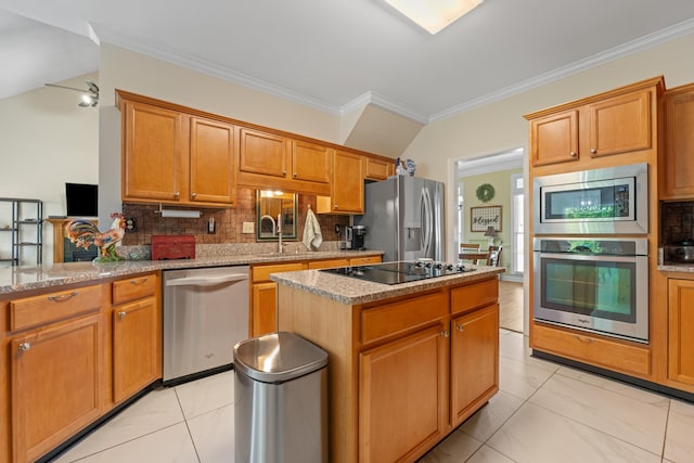 kitchen featuring crown molding, appliances with stainless steel finishes, backsplash, and a center island