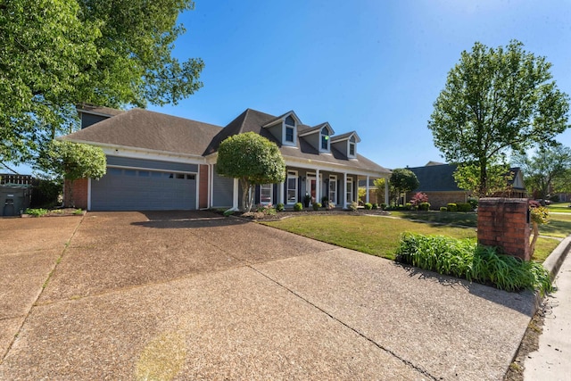 cape cod house featuring concrete driveway, a front yard, brick siding, a garage, and covered porch