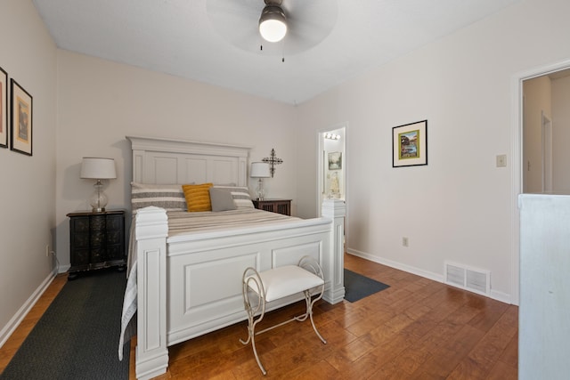 bedroom with ensuite bathroom, a ceiling fan, visible vents, wood finished floors, and baseboards