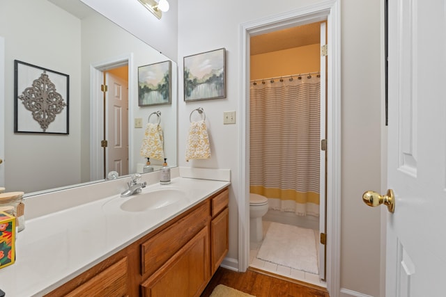 bathroom with vanity, toilet, wood finished floors, a shower with shower curtain, and baseboards