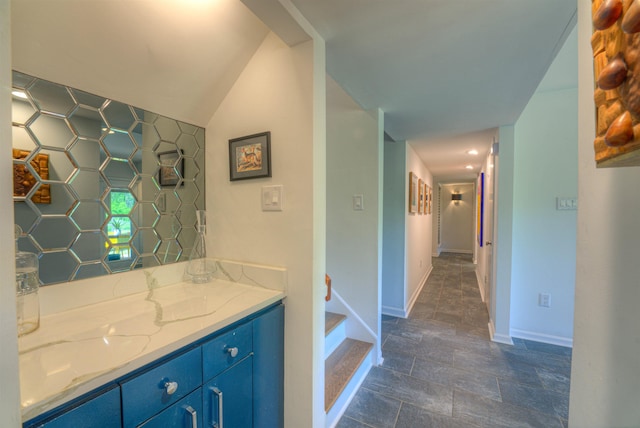 bathroom featuring vanity, baseboards, and stone finish floor