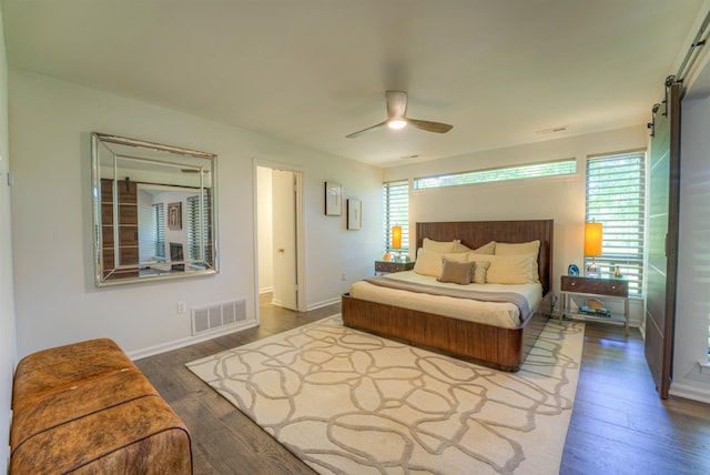 bedroom featuring ceiling fan, baseboards, wood finished floors, and visible vents