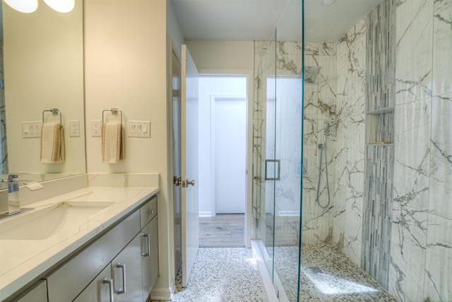 bathroom with a marble finish shower and vanity