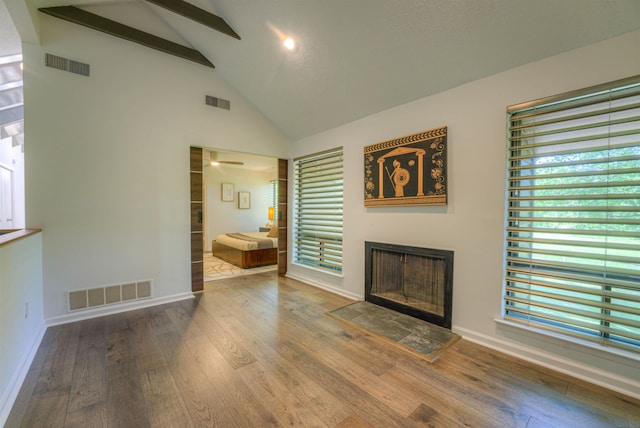 unfurnished living room with a fireplace, wood finished floors, visible vents, and ceiling fan
